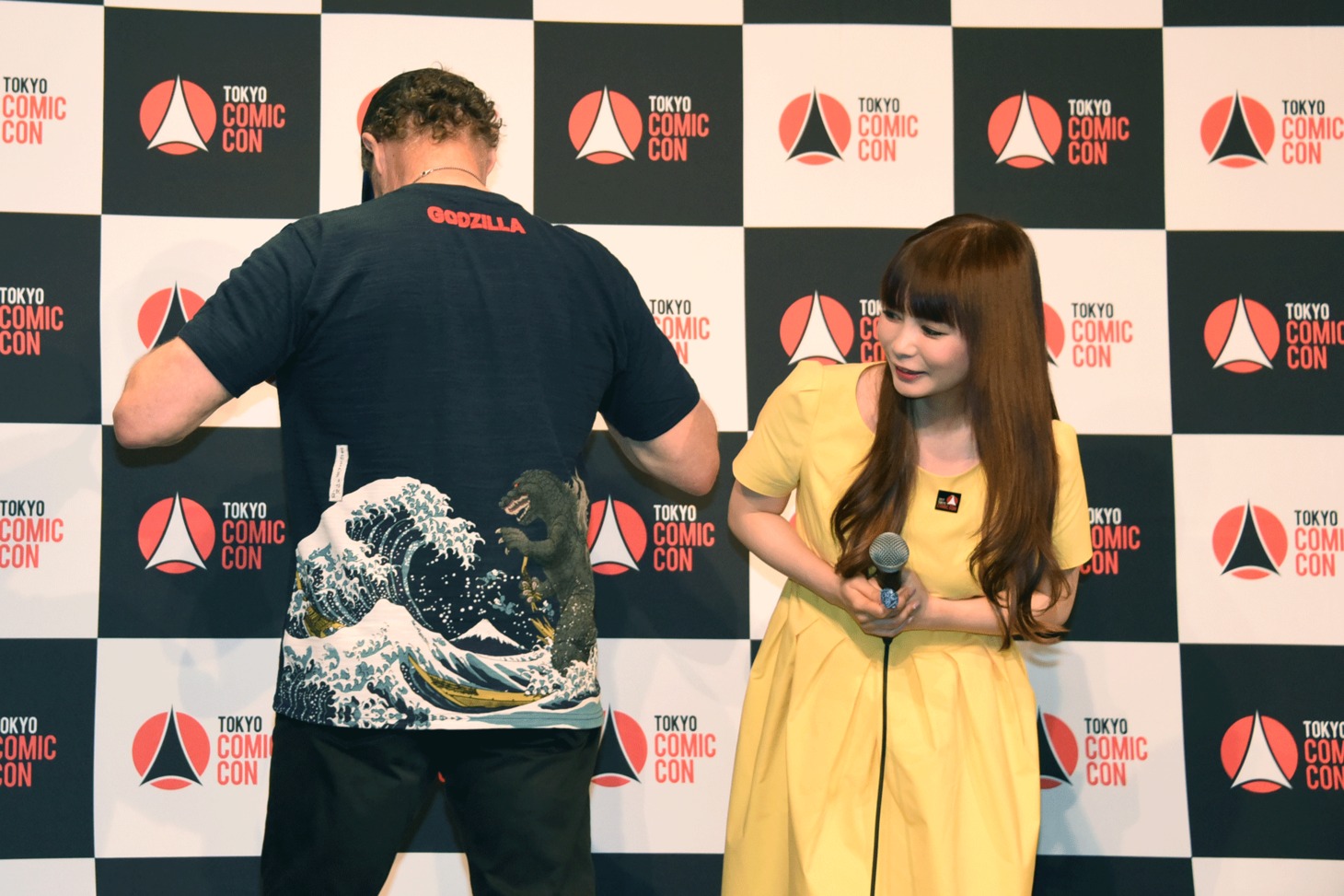Tシャツに描かれたゴジラを中川翔子（右）に見せるマイケル・ルーカー。