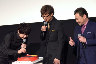 梶裕貴（左）が山寺宏一（中央）にファーストバイトを行う様子。