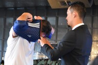 サッカーの日本代表ユニフォームに着替える小沢仁志。