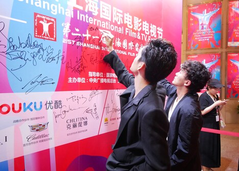 パネルにサインする池松壮亮（手前）と松居大悟（奥）。