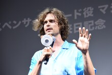 汗をかきすぎたため、小型扇風機の風を顔に当てながら挨拶をするマシュー・グレイ・ギュブラー。