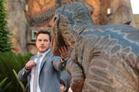 ラプトル“ブルー”のあごをなでるクリス・プラット。