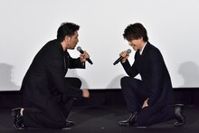ひざまずいて向かい合う別所哲也（左）と岩田剛典（右）。