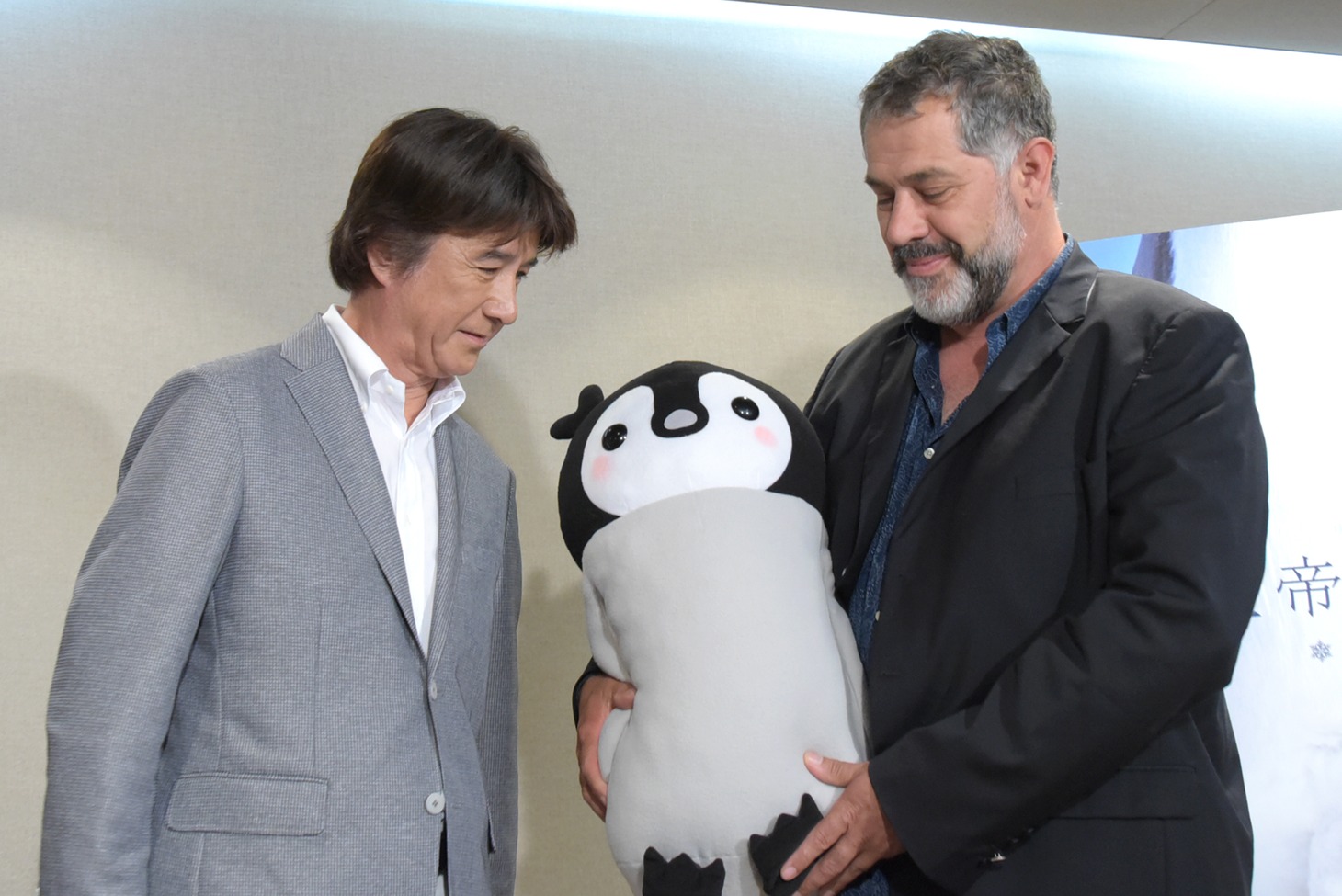 ぺんたのぬいぐるみを見るリュック・ジャケ（右）と草刈正雄（左）。
