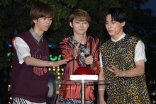 イルミネーション点灯ボタンに手を伸ばすリョウガ（左）、ユーキ（中央）、ユースケ（右）。