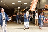 劇場前でビラ配りをするキャストたち。