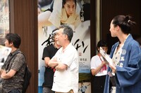 劇場前でビラ配りをするスタッフ・キャストたち。