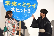 巨大なうちわを持つ上白石萌歌（左）の手助けをする星野源（右）。