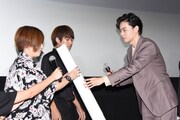 観客にサイン入りポスターを渡す菅田将暉(右)。