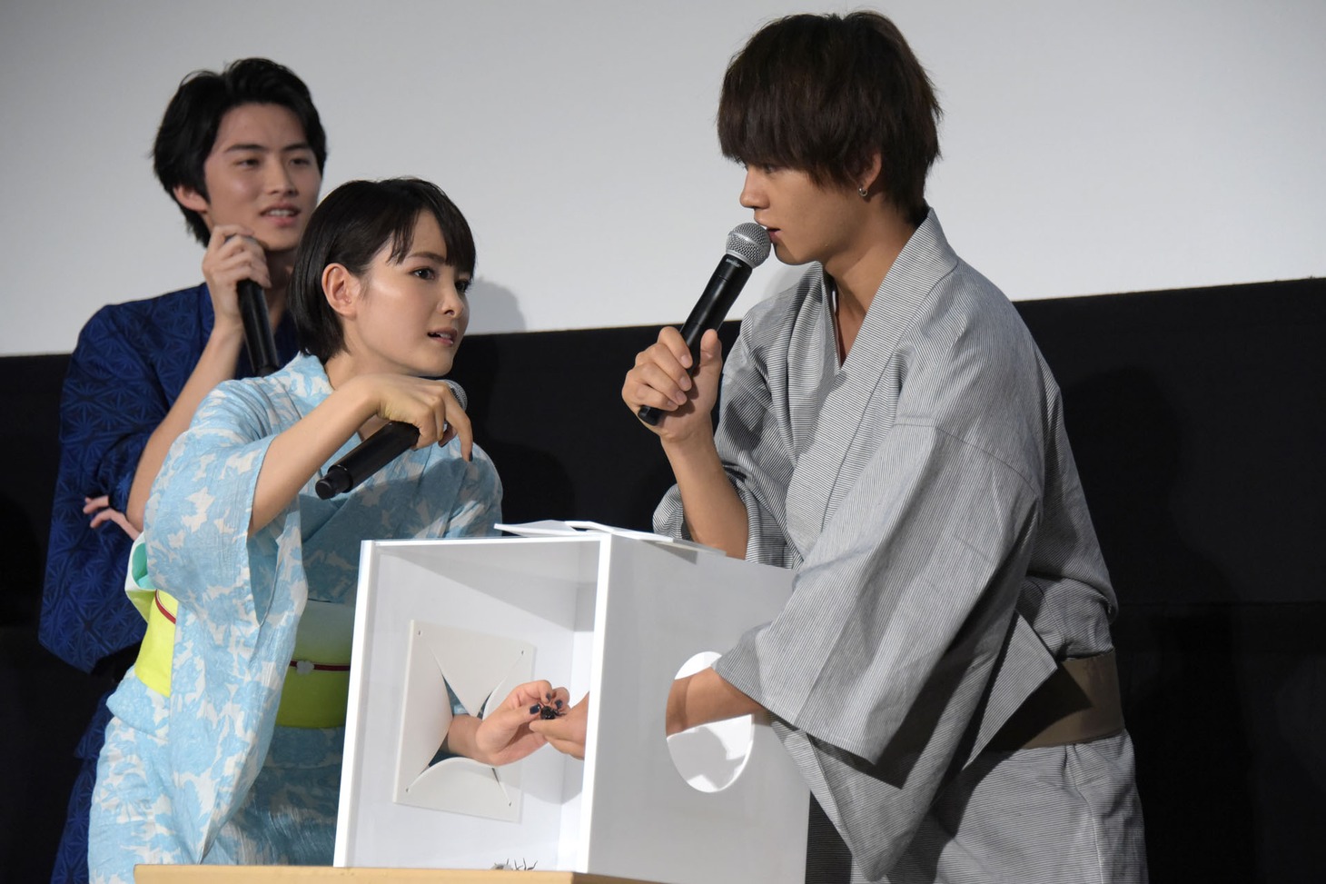 箱の中で葵わかな（左）へセミの模型を手渡す佐野勇斗（右）。