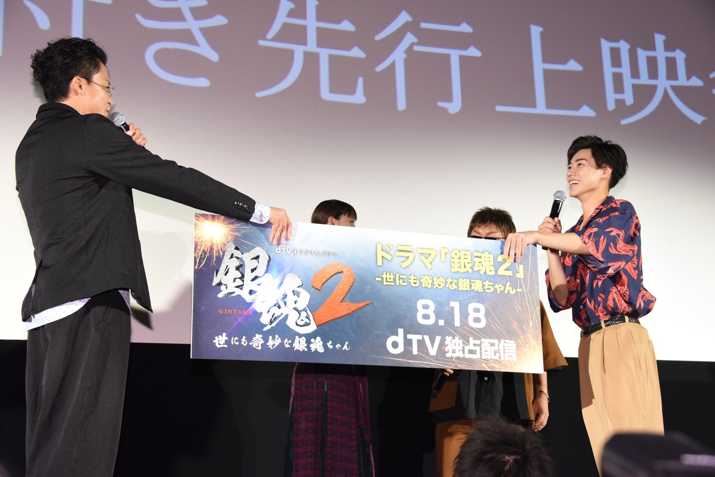 フォトセッション用のパネルを戸塚純貴（右）に手渡す小栗旬（左）。