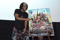 ポスターにマイクを向けるフライング・ロータス。