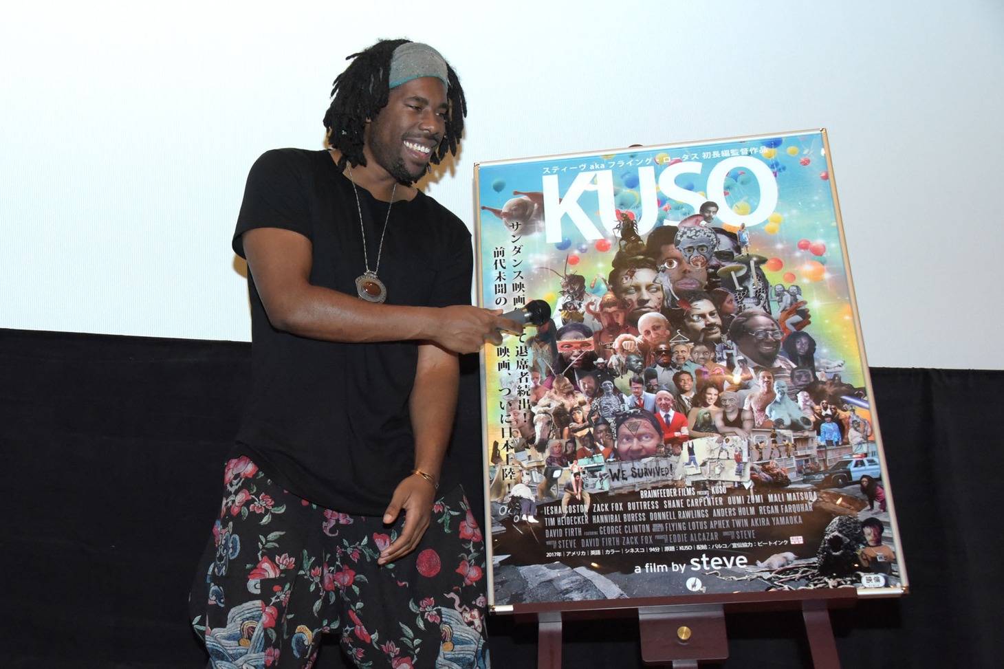 ポスターにマイクを向けるフライング・ロータス。