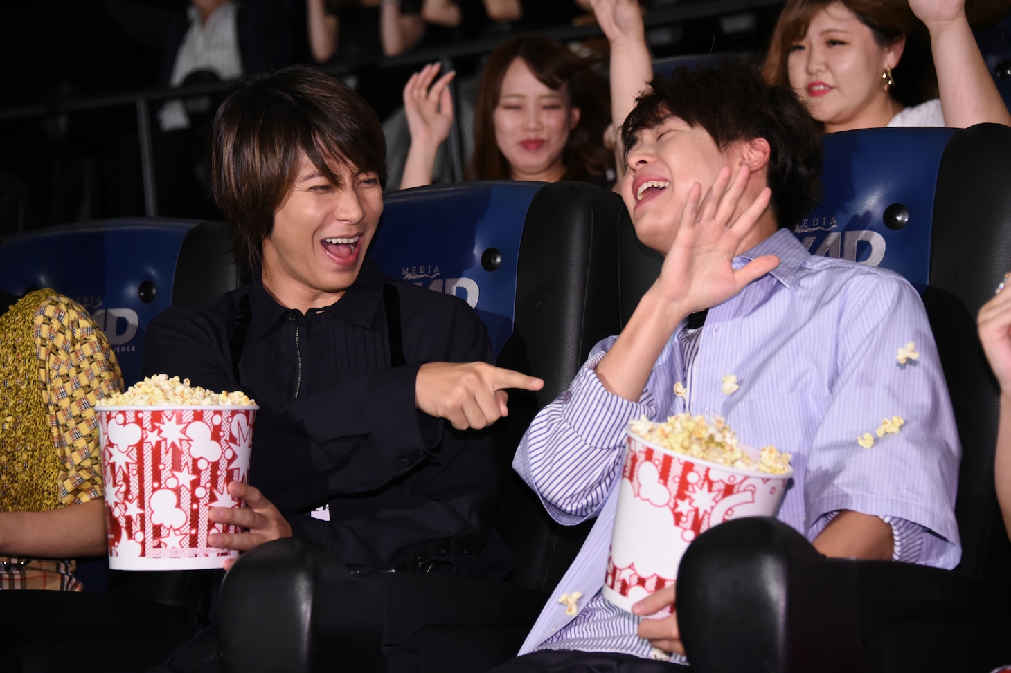 左から山下智久、有岡大貴。MX4Dのエフェクトである風で有岡のポップコーンが飛ぶ瞬間。