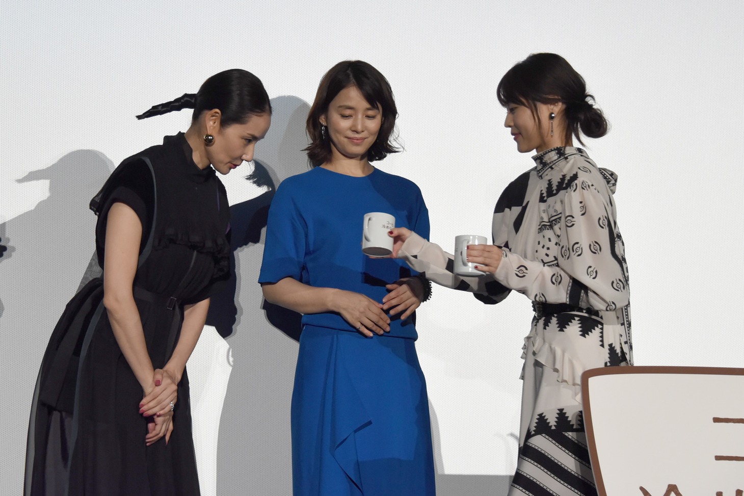 コーヒーを共演者たちに手渡す有村架純。