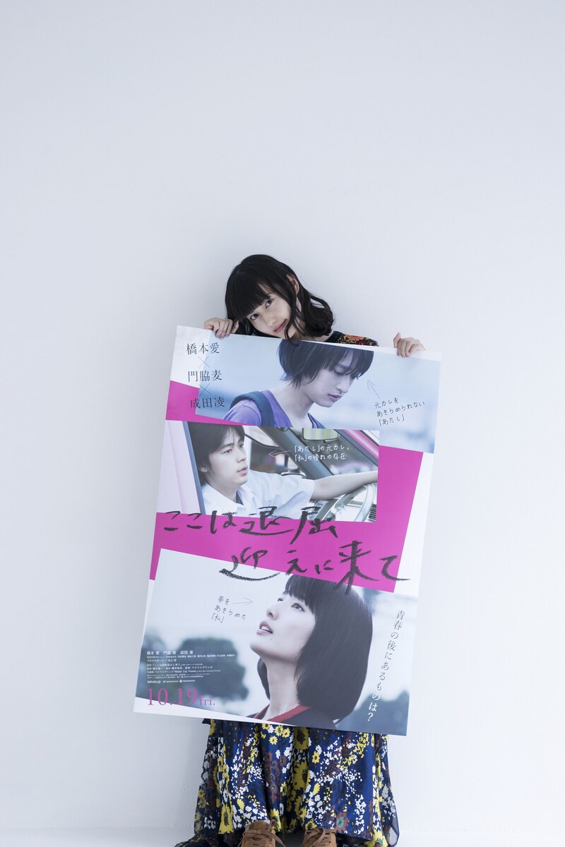 自身がタイトルを書き入れた「ここは退屈迎えに来て」ポスターを持つ橋本愛。