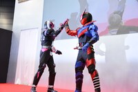 ハイタッチする仮面ライダービルド（右）と仮面ライダージオウ（左）。