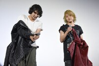 会場の暑さに衣装を脱ぎ出す藤田玲（左）と佐藤流司（右）。