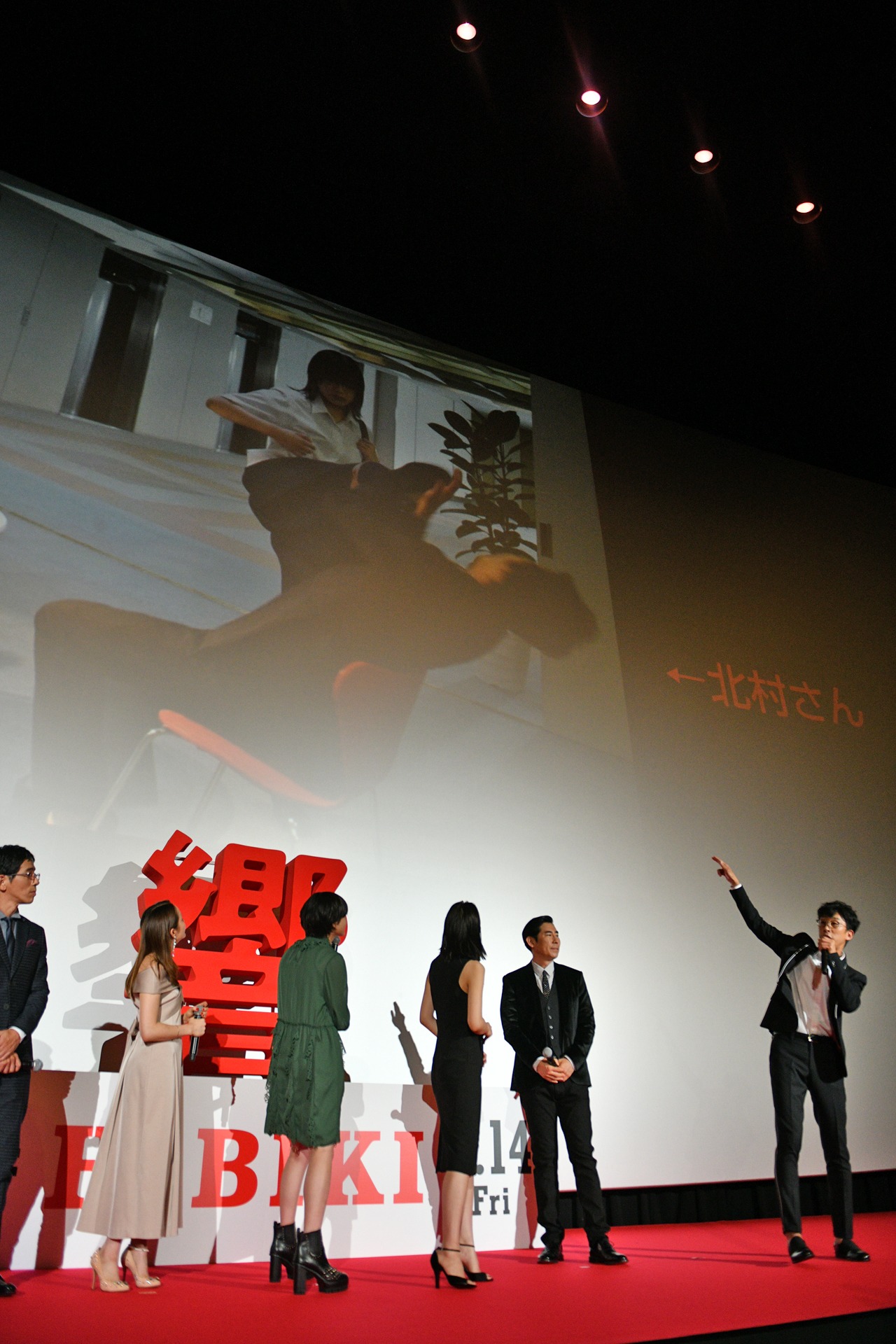 響に回し蹴りされるシーンを説明する北村有起哉（右）。