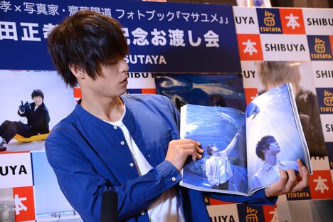 お気に入りの写真が載ったページを広げる窪田正孝。