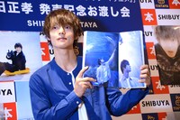 お気に入りの写真が載ったページを広げる窪田正孝。