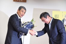東映の社長・多田憲之氏（右）から花束を受け取った舘ひろし（左）。