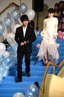 階段を降りる岩田剛典（左）と杉咲花（右）。