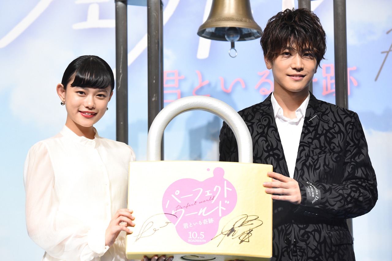 南京錠を持った杉咲花（左）と岩田剛典（右）。