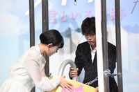 南京錠をかける杉咲花（左）と岩田剛典（右）。