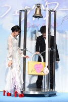 南京錠をかける杉咲花（左）と岩田剛典（右）。