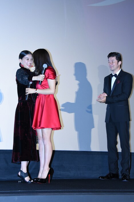 抱き合う土屋太鳳と芳根京子を見守る浅野忠信（右）。