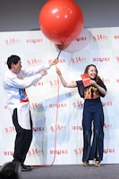 風船の膨らむ勢いに驚く笠松将（左）とアヤカ・ウィルソン（右）。