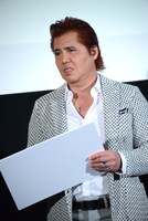 舌を出しながら熟考する竹内力。