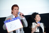 「うんこ」のフリップを掲げる竹内力（左）。