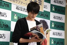 “沖縄×結木滉星”というテーマに沿って、お気に入りのページを選ぶ結木滉星。