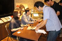 サイン会を行う唐田えりか（左手前）と濱口竜介（左奥）。