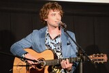 ギターで弾き語りを披露するジョシュ・ホワイトハウス。