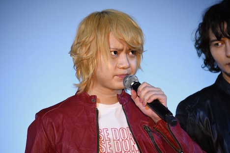 ゆるんだ表情をマスコミに撮られまいとキメ顔のまま挨拶する佐藤流司。