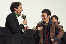 マッスルポーズを決める草なぎ剛（右）と笑う満島真之介（左）。