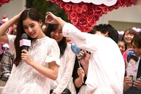 新木優子（左）の髪に付いた紙吹雪を取る吉沢亮（右）。