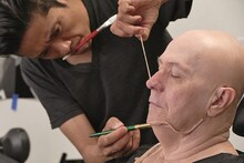 辻一弘（左）に特殊メイクを施されるゲイリー・オールドマン（右）。