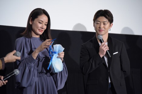 プレゼントの封を切る吉田羊（左）と佐野玲於（右）。