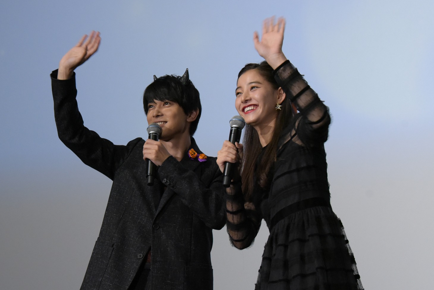 客席に手を振る吉沢亮（左）と新木優子（右）。
