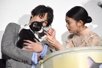 福士蒼汰（左）が抱くナナに猫用ミルクを飲ませようとする高畑充希（右）。