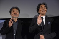 ムービーカメラに手を振る黒沢清（左）と役所広司（右）。