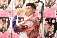 私物のバラ鞭を持ち、哺乳瓶でお茶を飲む高嶋政宏。