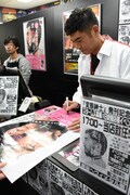 ポスターにサインする高嶋政宏。