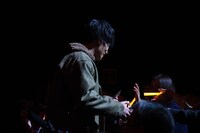 観客にポストカードを配る鈴木伸之。