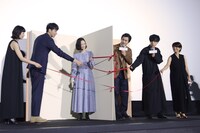 特大の本を開く登壇者たち。