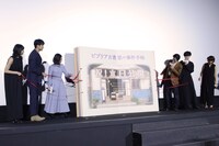 特大の本を開く登壇者たち。